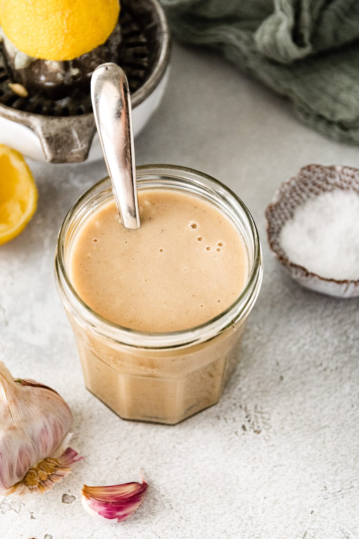 tahini dressing in jar with spoon. 