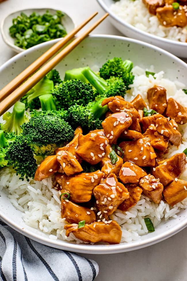 chicken teriyaki with broccoli and rice in a bowl with chopsticks