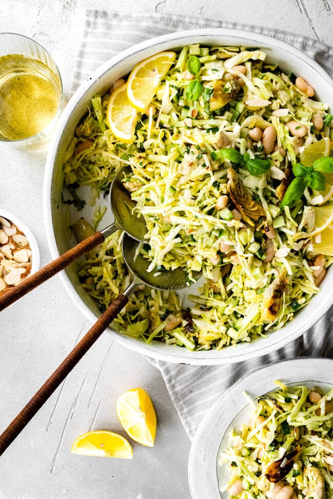 crispy artichoke white bean salad in bowl with salad server