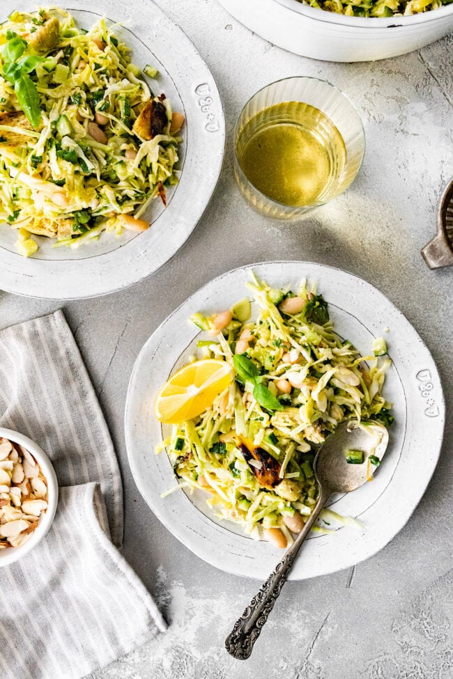 crispy artichoke white bean salad on plates with lemon