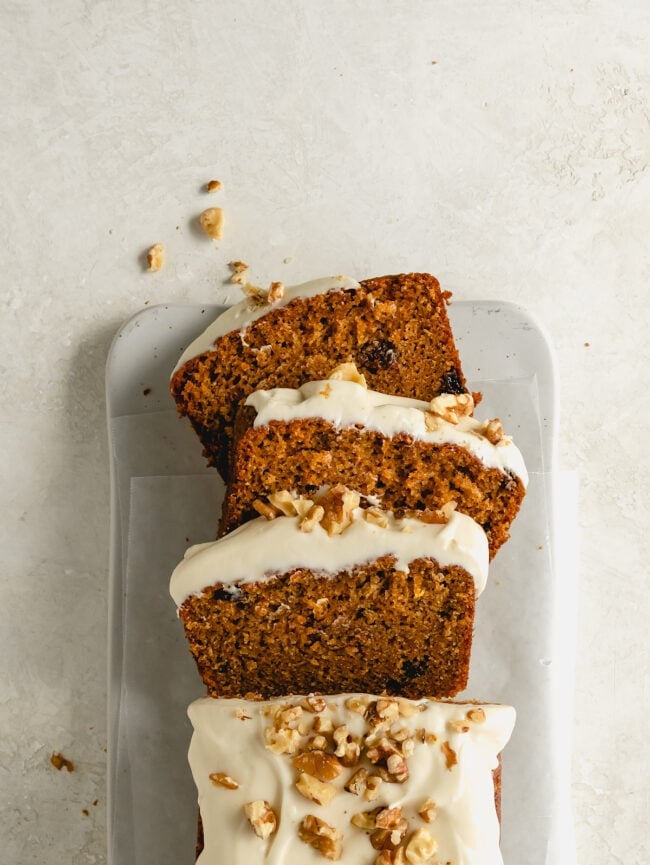 carrot cake loaf cut in slices with cream cheese frosting