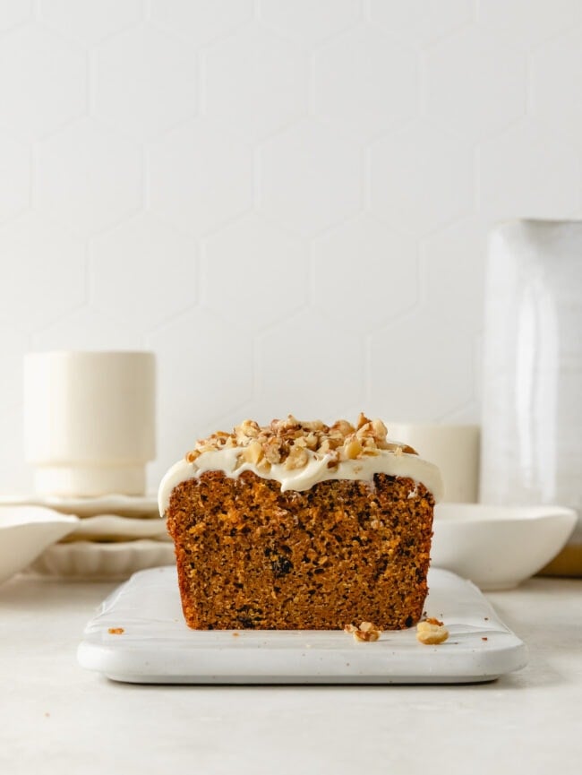 carrot cake loaf with cream cheese frosting and walnut topping