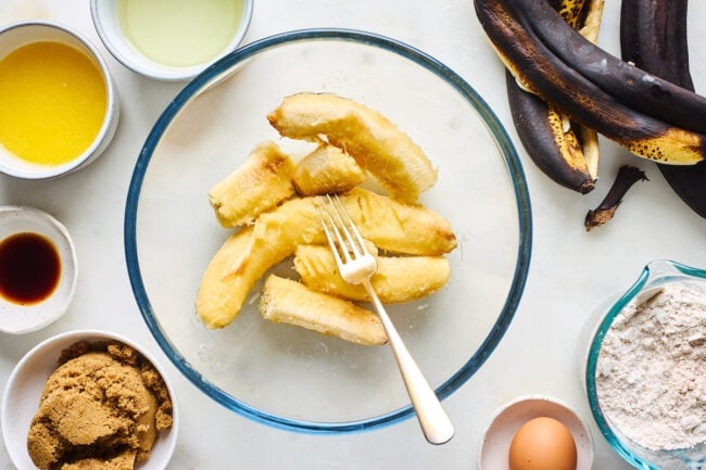 bananas in bowl with fork to make banana bread.