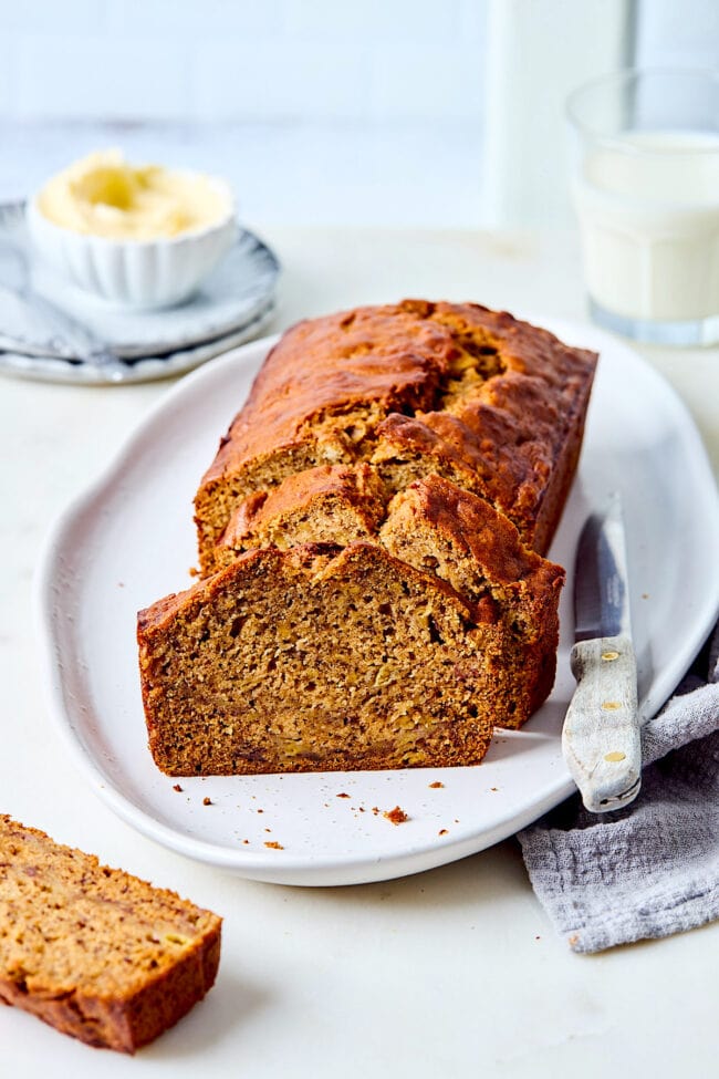 banana bread on platter cut into slices with knife.