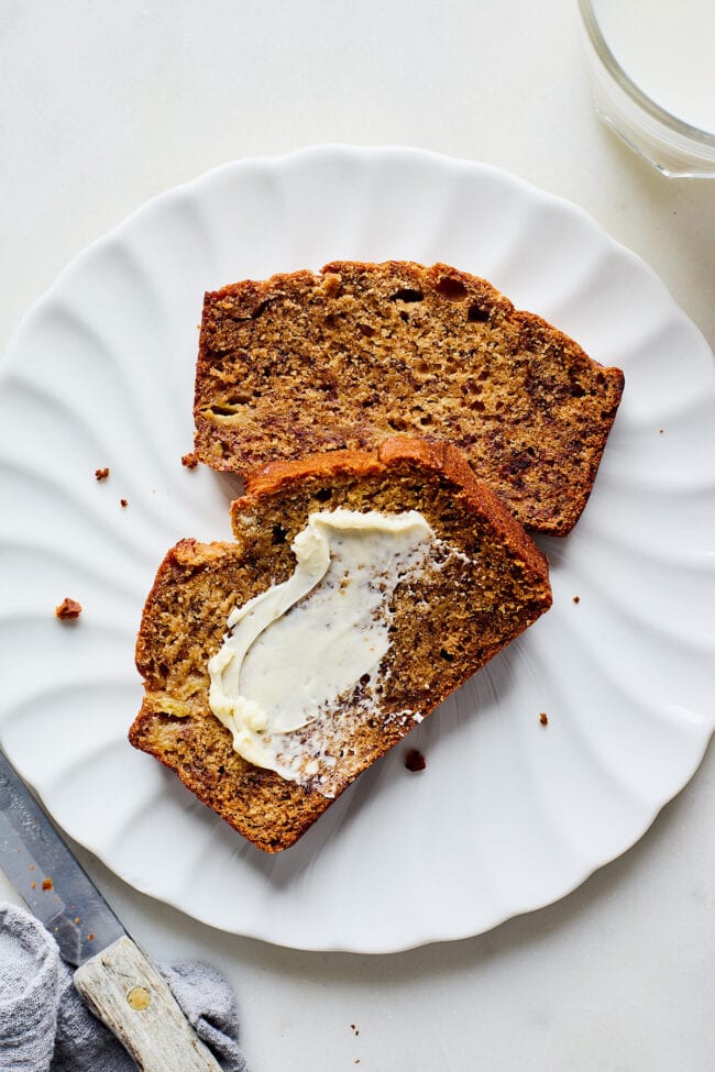 banana bread slices on plate with butter.