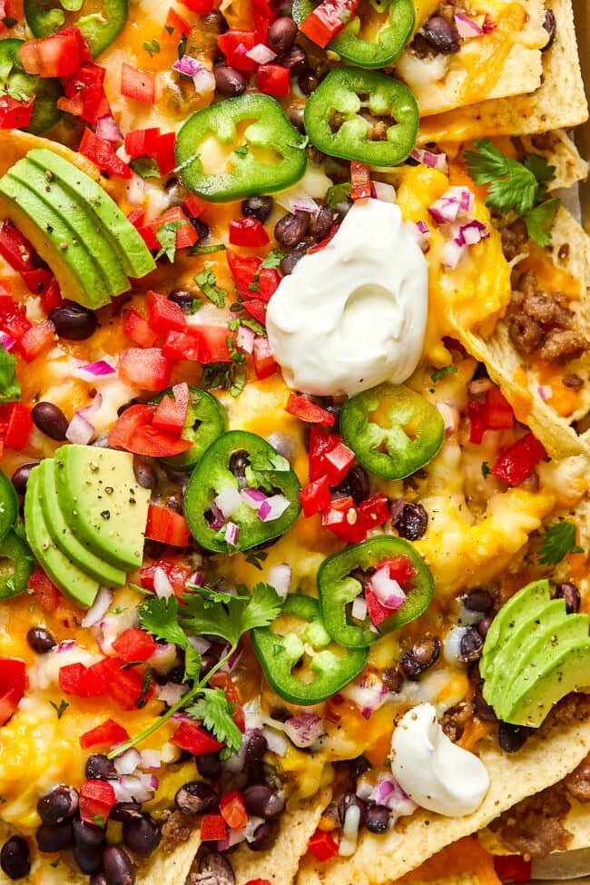 breakfast nachos with sausage, eggs, cheese, beans, and toppings