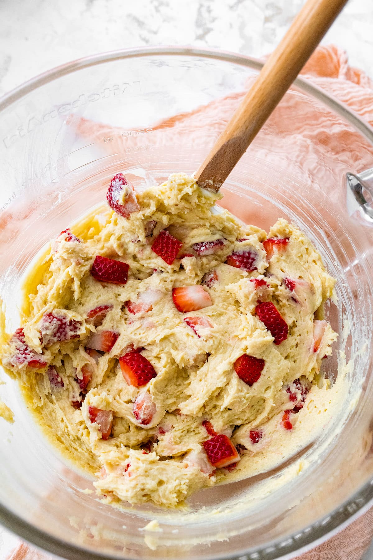 strawberry muffin batter in glass bowl with spatula.