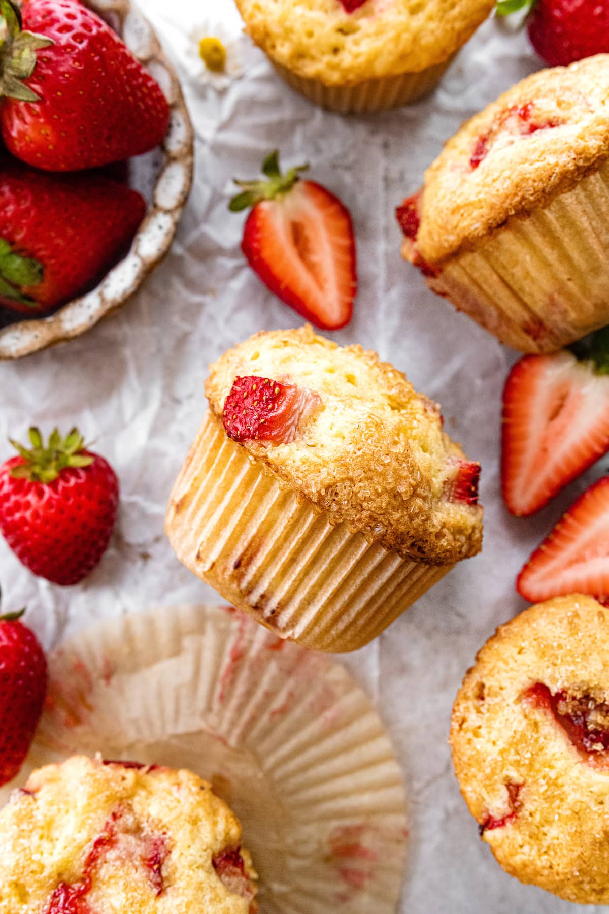 strawberry muffins in paper liner with fresh strawberries. 