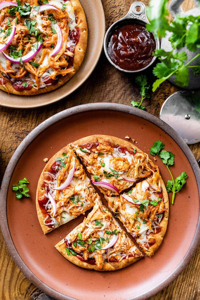 BBQ chicken pita pizza on plate cut in slices. 