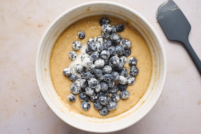 banana bread batter in bowl with blueberries.