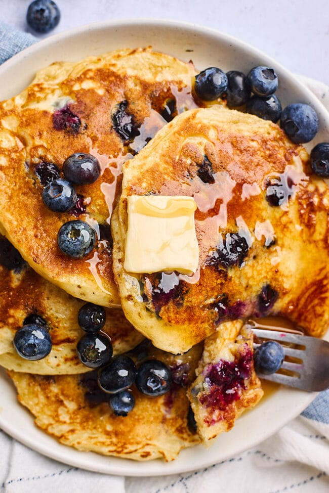 blueberry pancakes with butter and maple syrup.