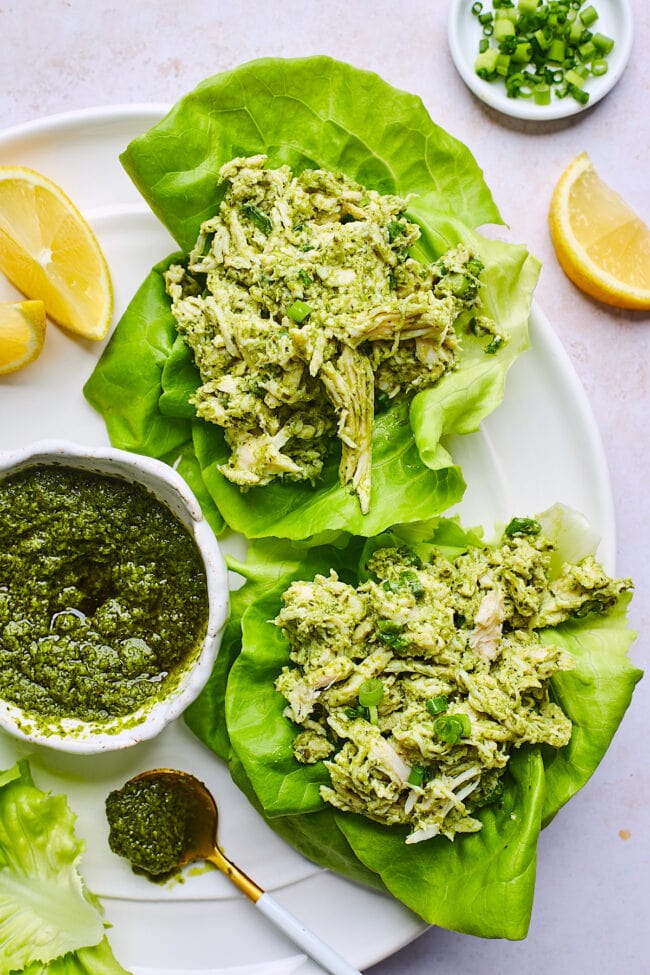 pesto chicken salad in lettuce cups on plate.