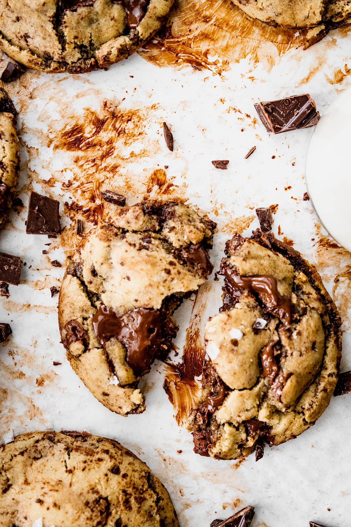 chocolate chip cookie cut in half on baking sheet with parchment paper. 