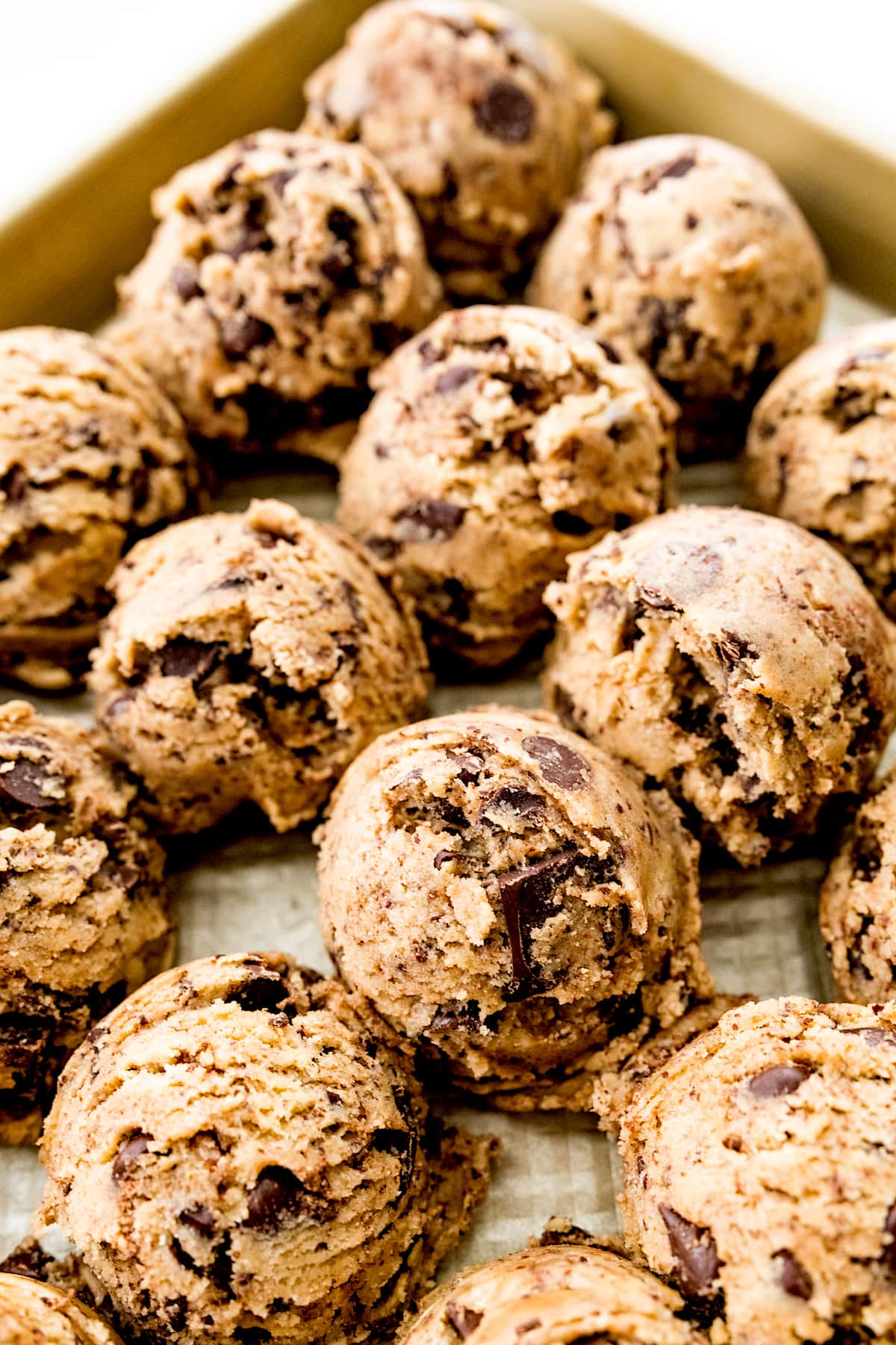 chocolate chip cookie dough balls on baking sheet. 