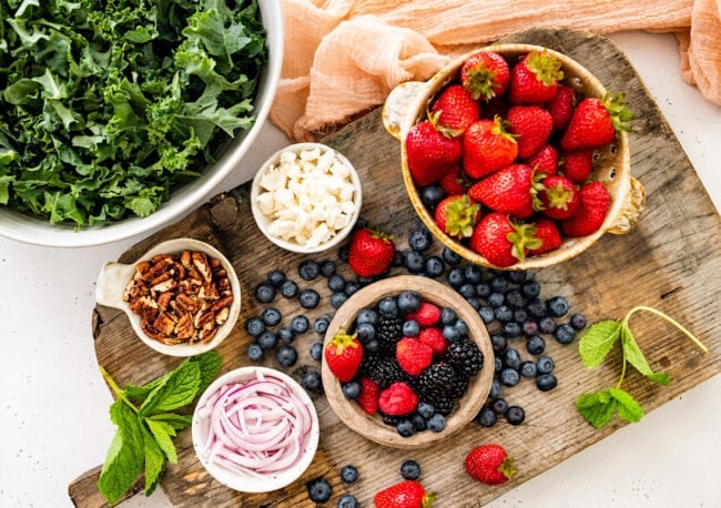 ingredients for berry kale salad on cutting board. 