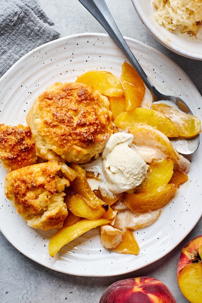 peach cobbler with vanilla ice cream in bowl.