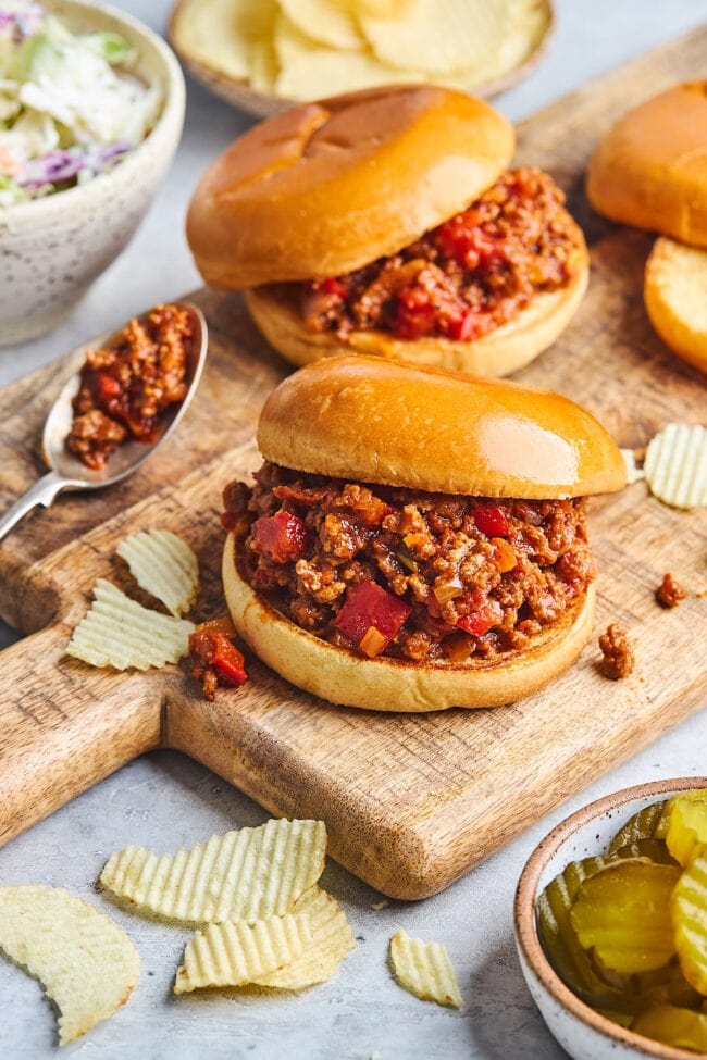 sloppy joe sandwiches on wood cutting board.