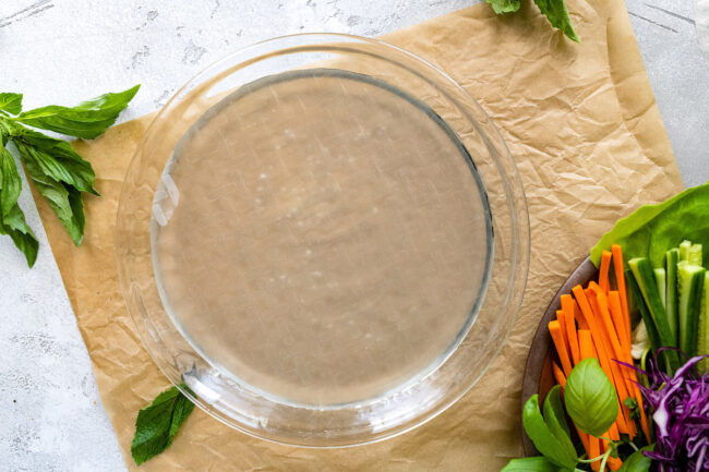 rice paper in bowl of water to make spring rolls.