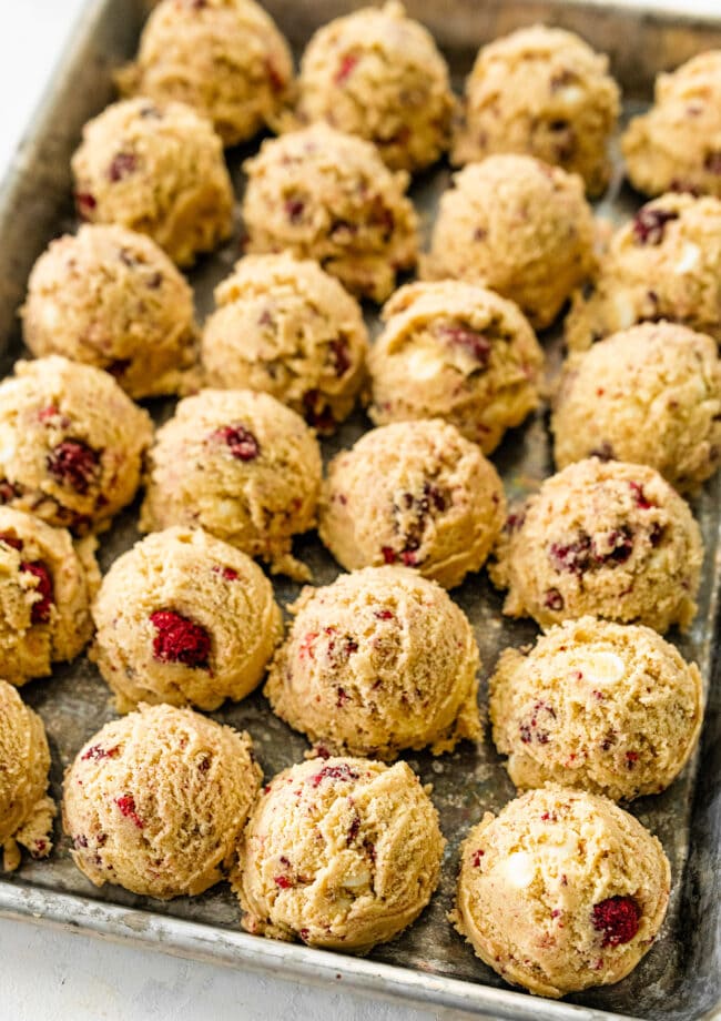 white chocolate raspberry cookie dough balls on baking sheet.