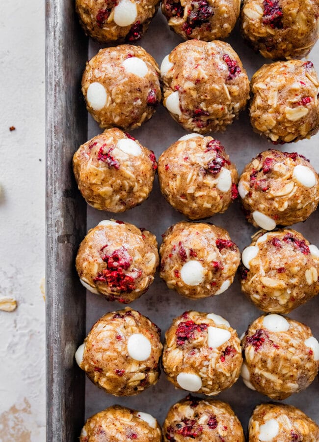 white chocolate raspberry energy balls on baking sheet.