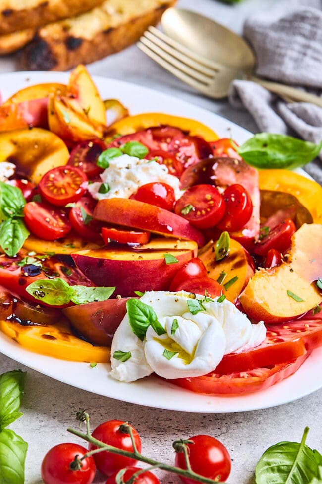 tomato peach burrata salad on platter.