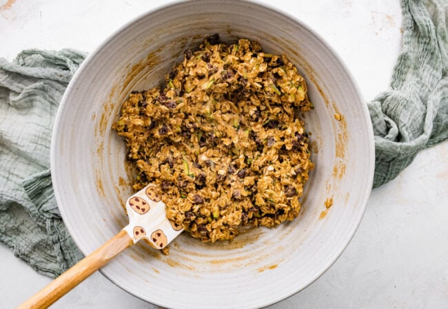 brown butter zucchini oatmeal chocolate chip cookie dough in bowl with spatula.