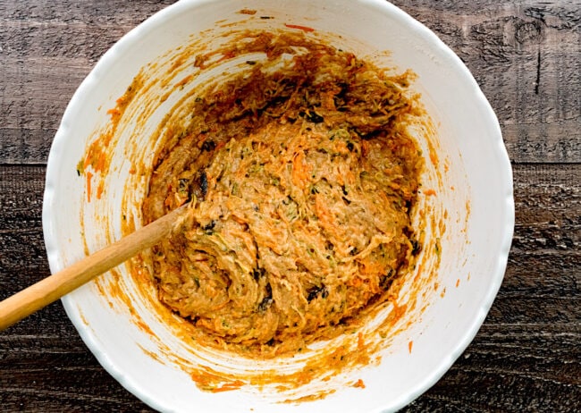 zucchini carrot muffin batter in bowl with spoon.