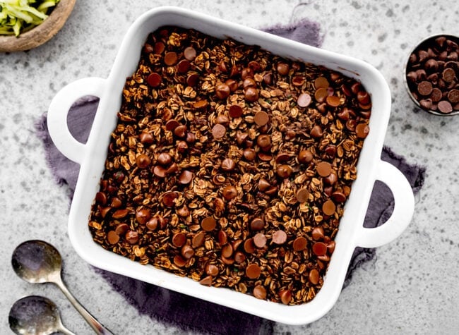 chocolate zucchini baked oatmeal in pan with chocolate chips. 