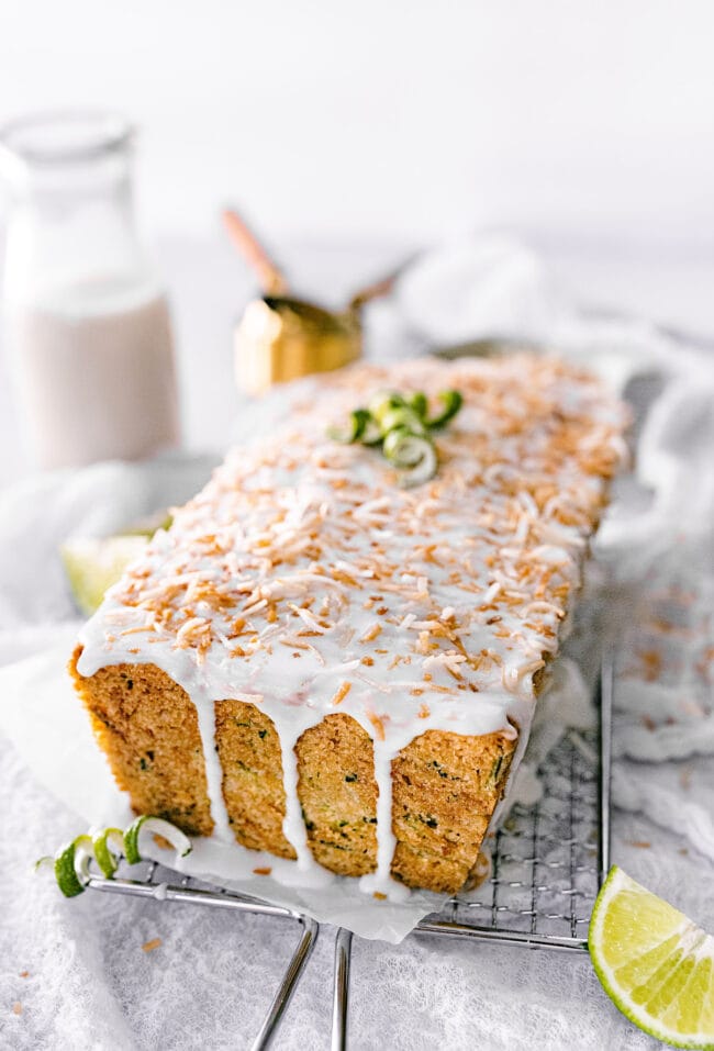lime zucchini loaf with lime glaze and toasted coconut on cooling rack.