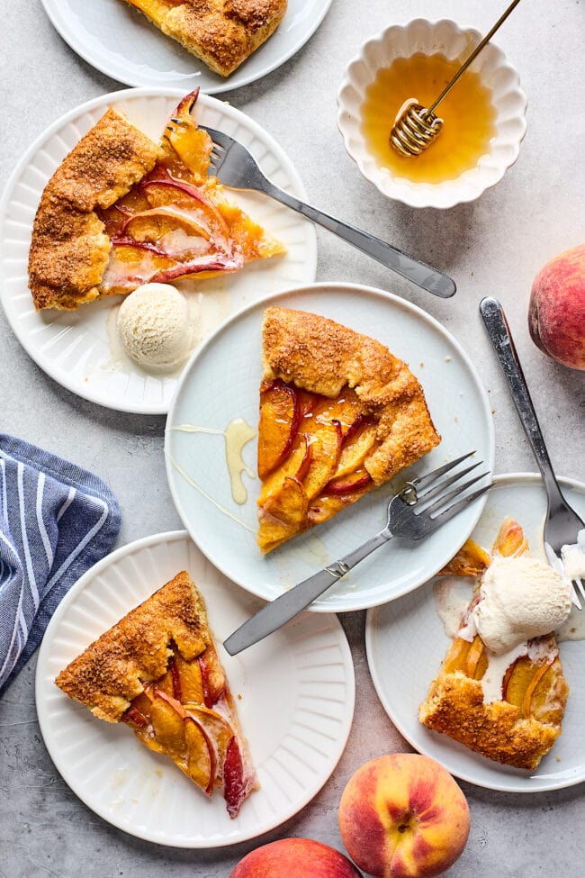 peach galette slices on plates with forks.