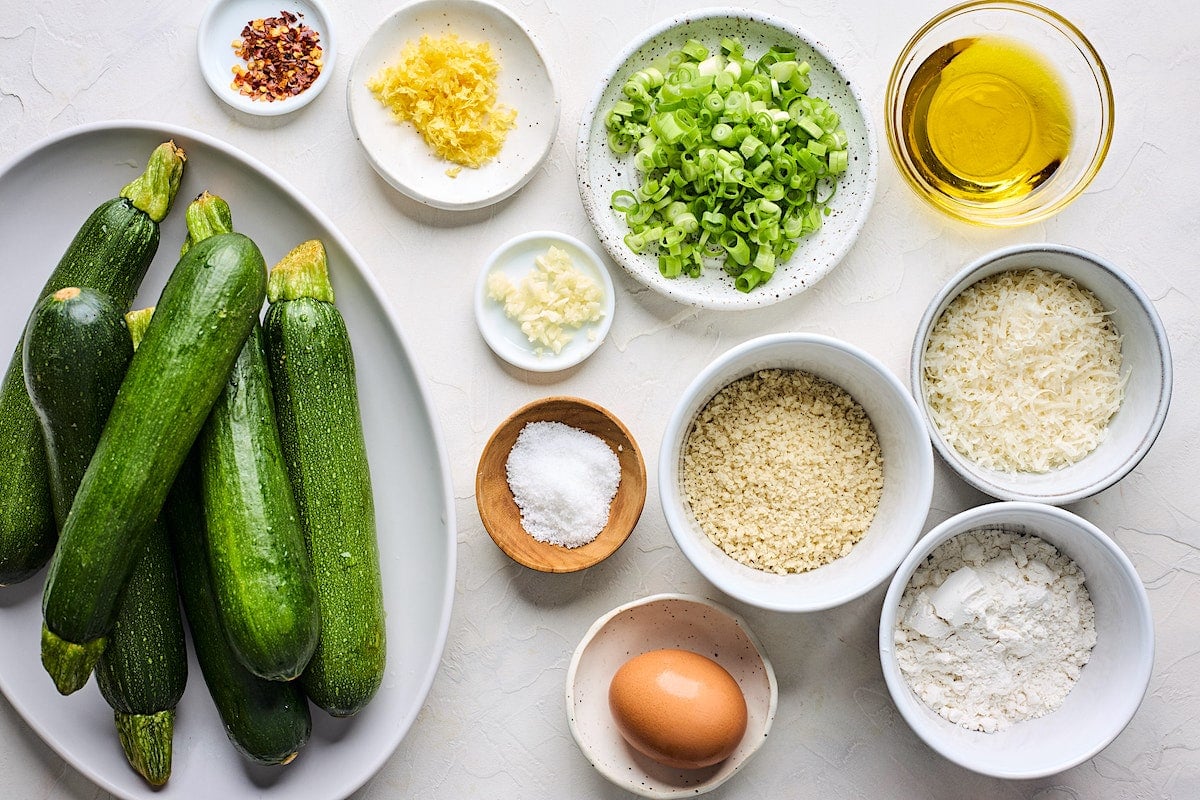 zucchini fritter ingredients in bowls. 
