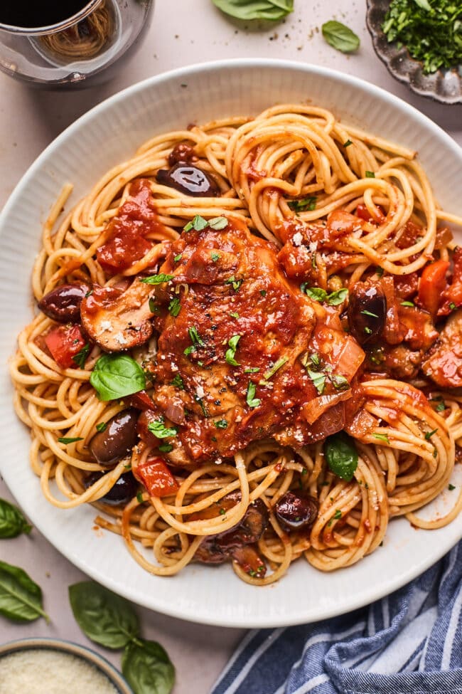 chicken cacciatore with pasta on plate.