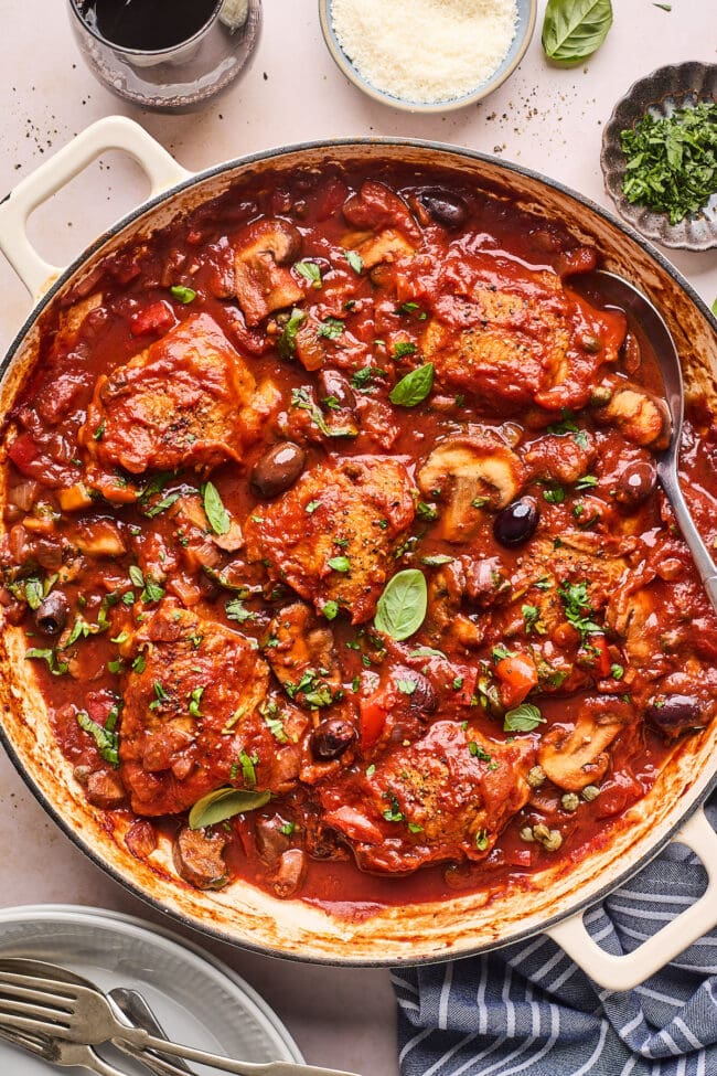 chicken cacciatore with tomato sauce in a pot with a spoon.