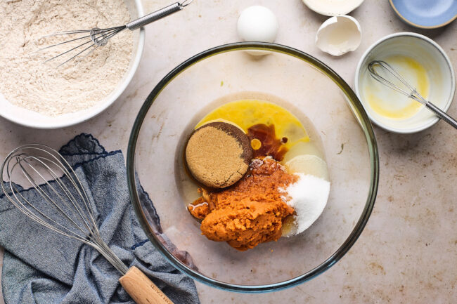 pumpkin zucchini bread ingredients in bowl with whisk. 