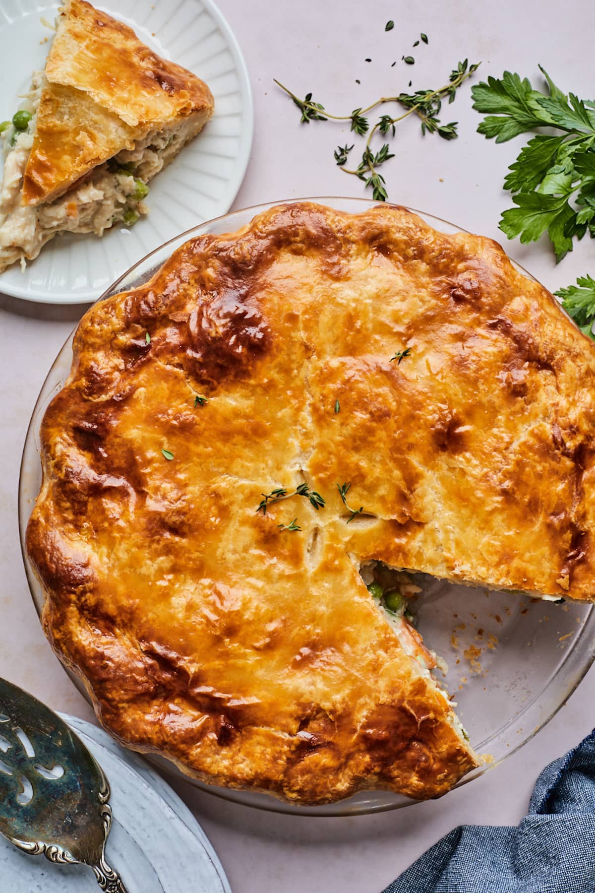 chicken pot pie in a pie dish with a piece on a plate.