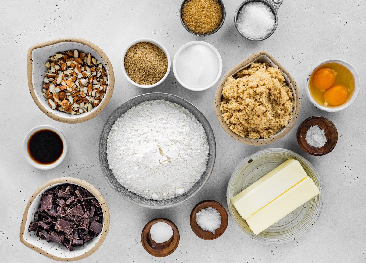 almond chocolate chip cookie ingredients measured out in small bowls. 