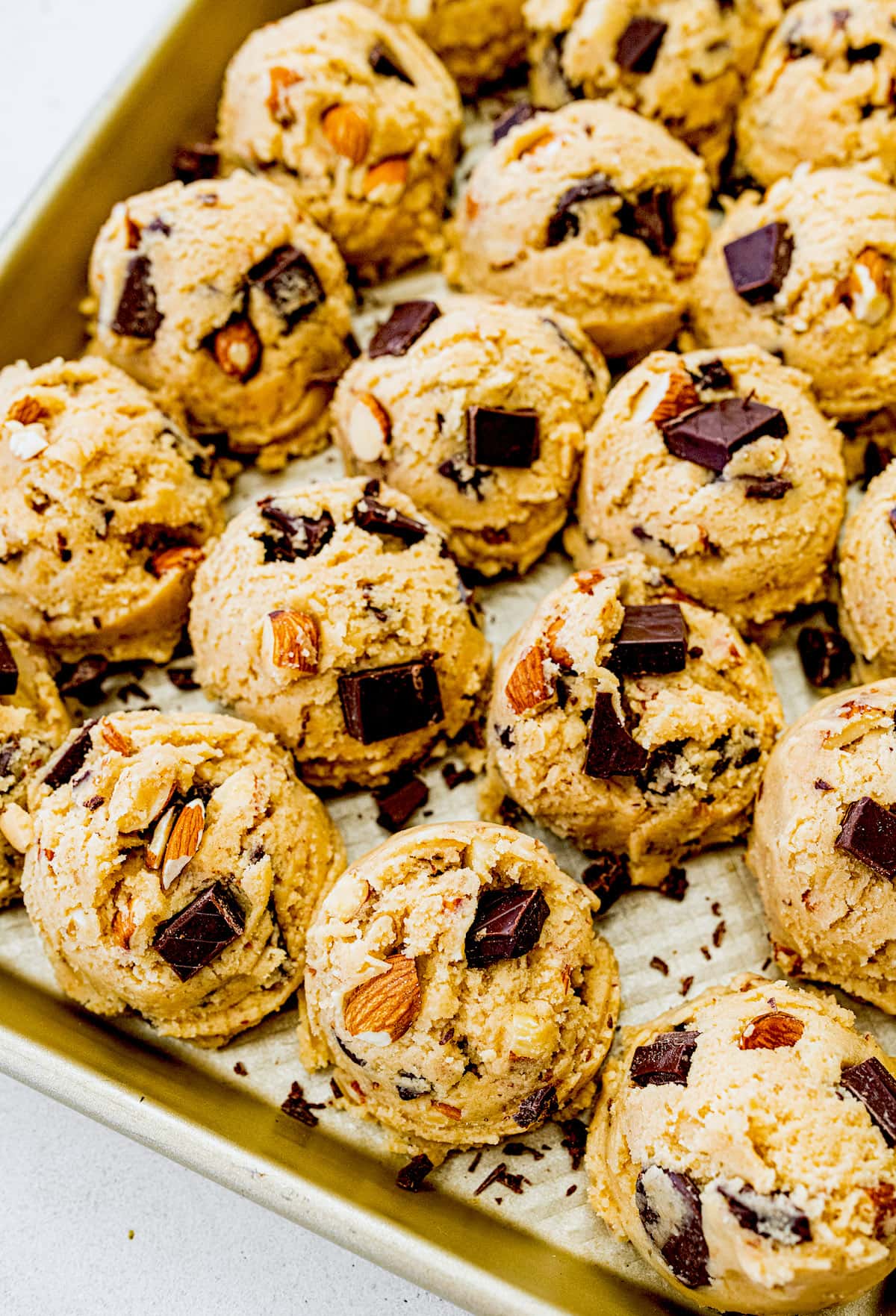 almond chocolate chip cookie dough balls on baking sheet. 
