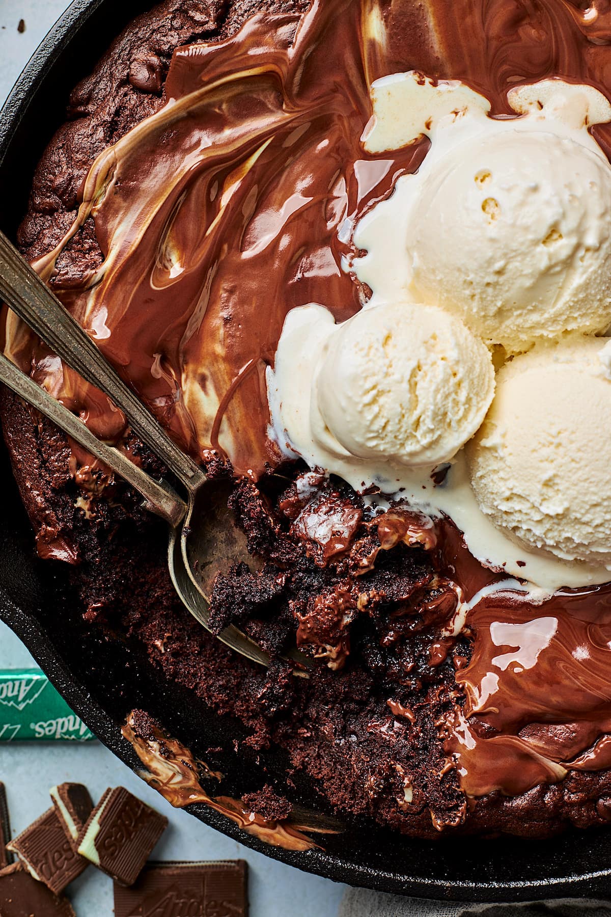 Andes mint skillet cookie with ice cream in skillet with spoons. 