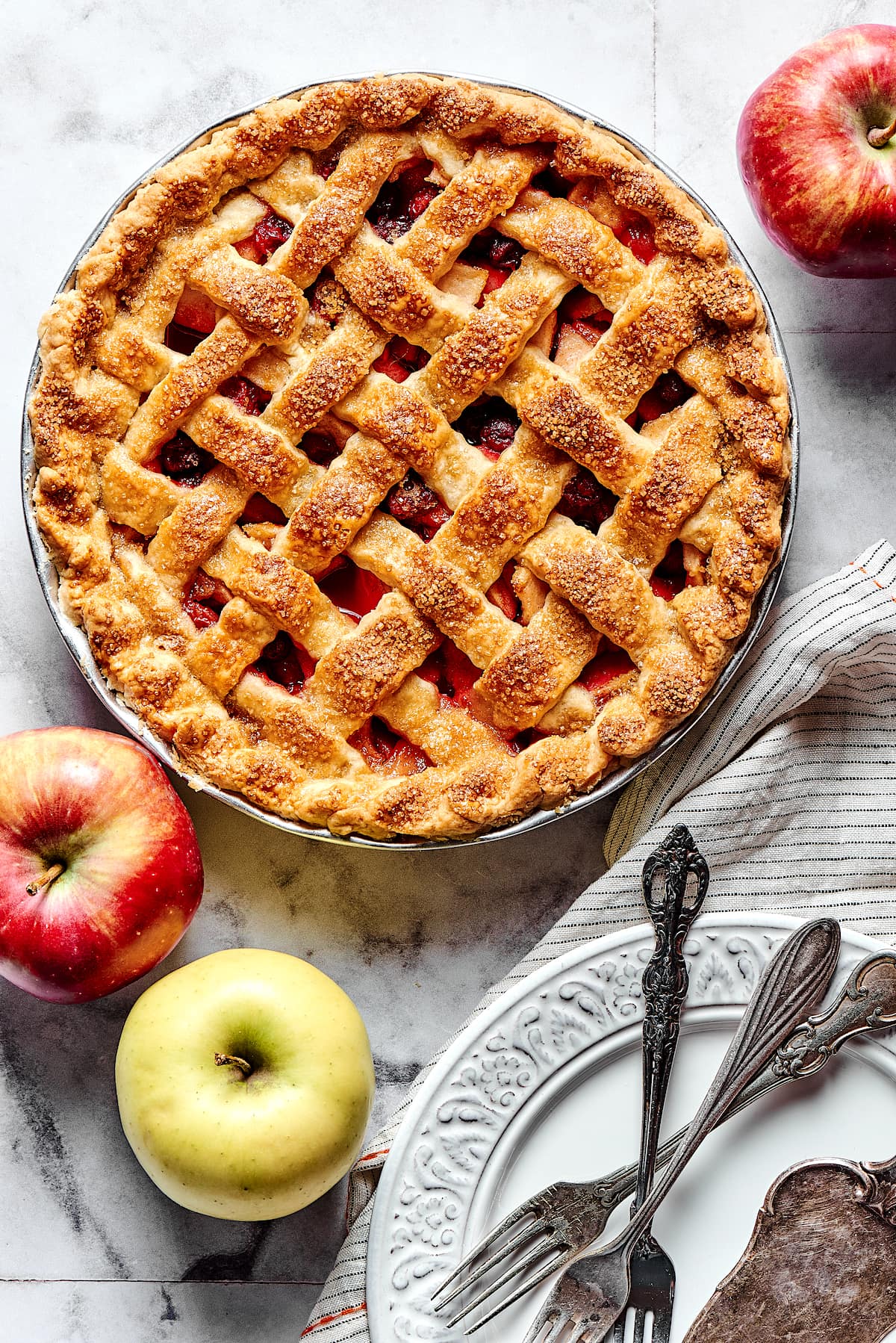 baked apple cranberry pie with lattice crust in pie pan.