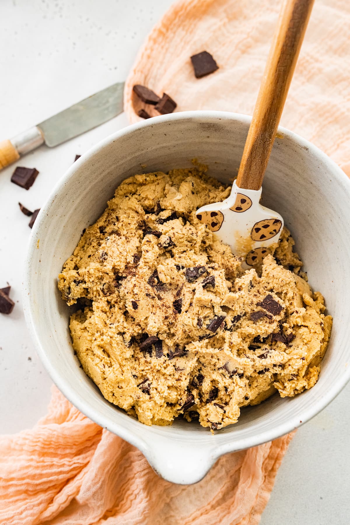 brown butter chocolate chip cookie dough in mixing bowl with spatula.