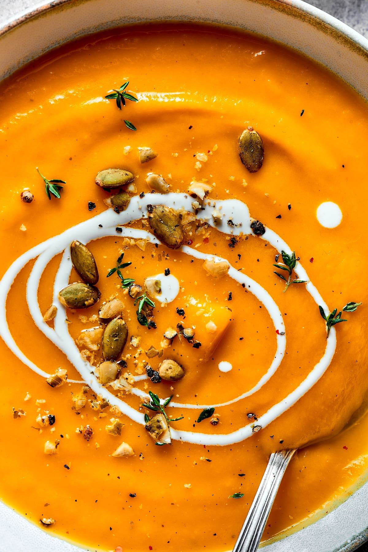 butternut squash soup in bowl with toppings. 
