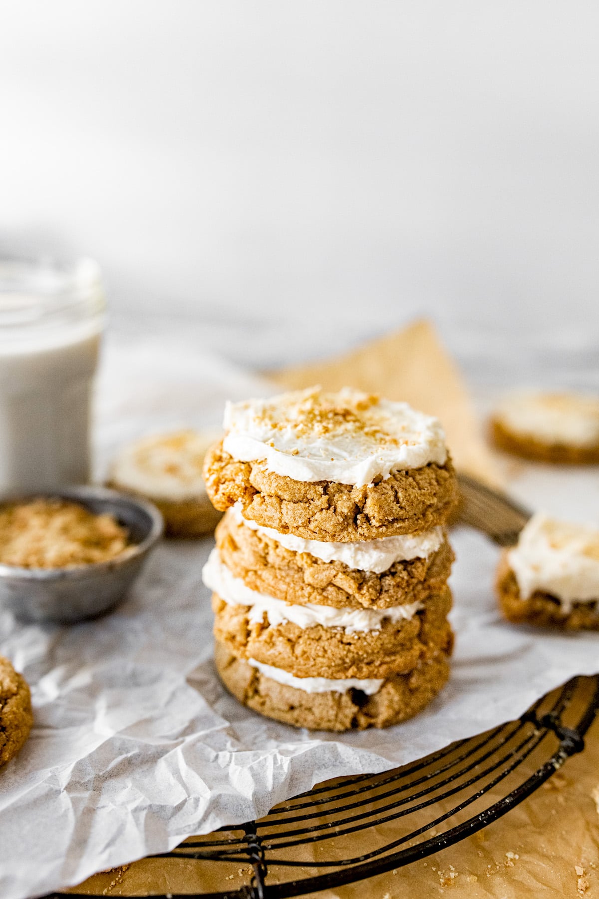 stack of graham cracker cookies with frosting on cooling rack. 