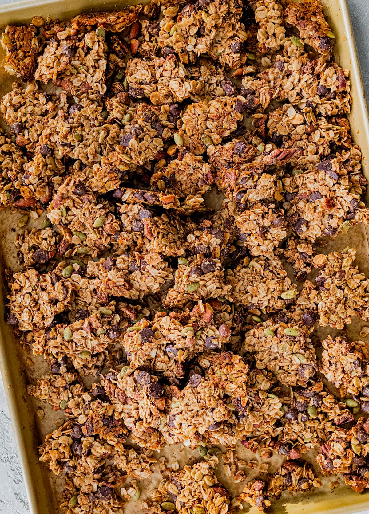 chocolate chip cookie granola clusters on large baking sheet. 