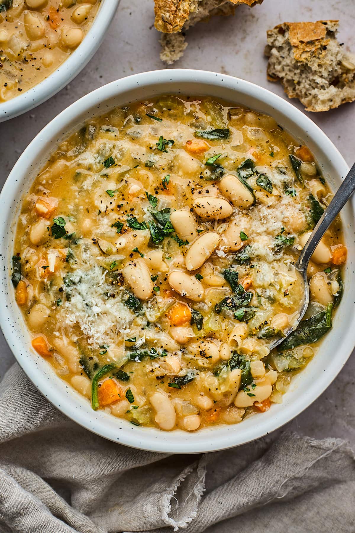 white bean soup in bowl with spoon. 