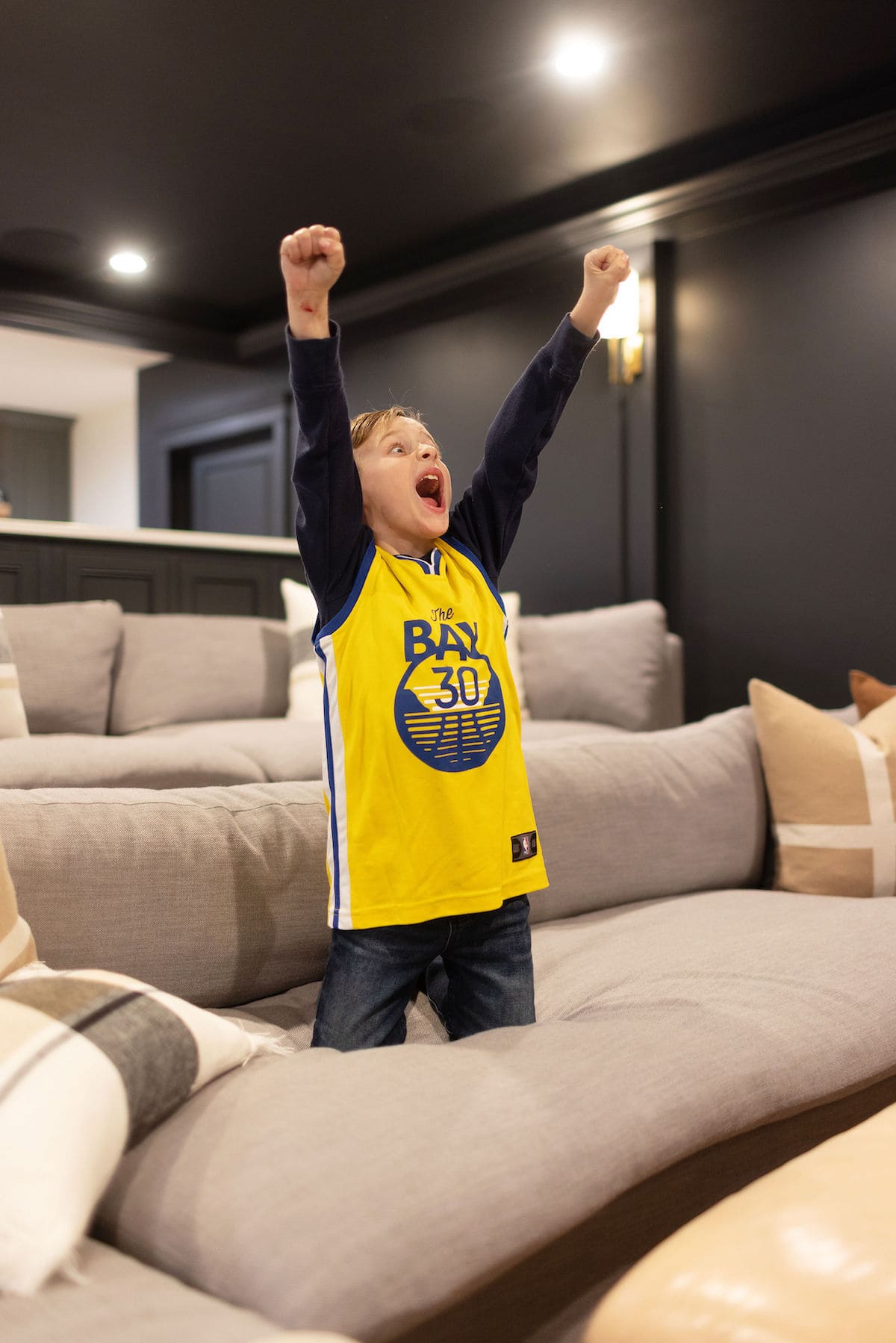 kid watching game in theatre room. 