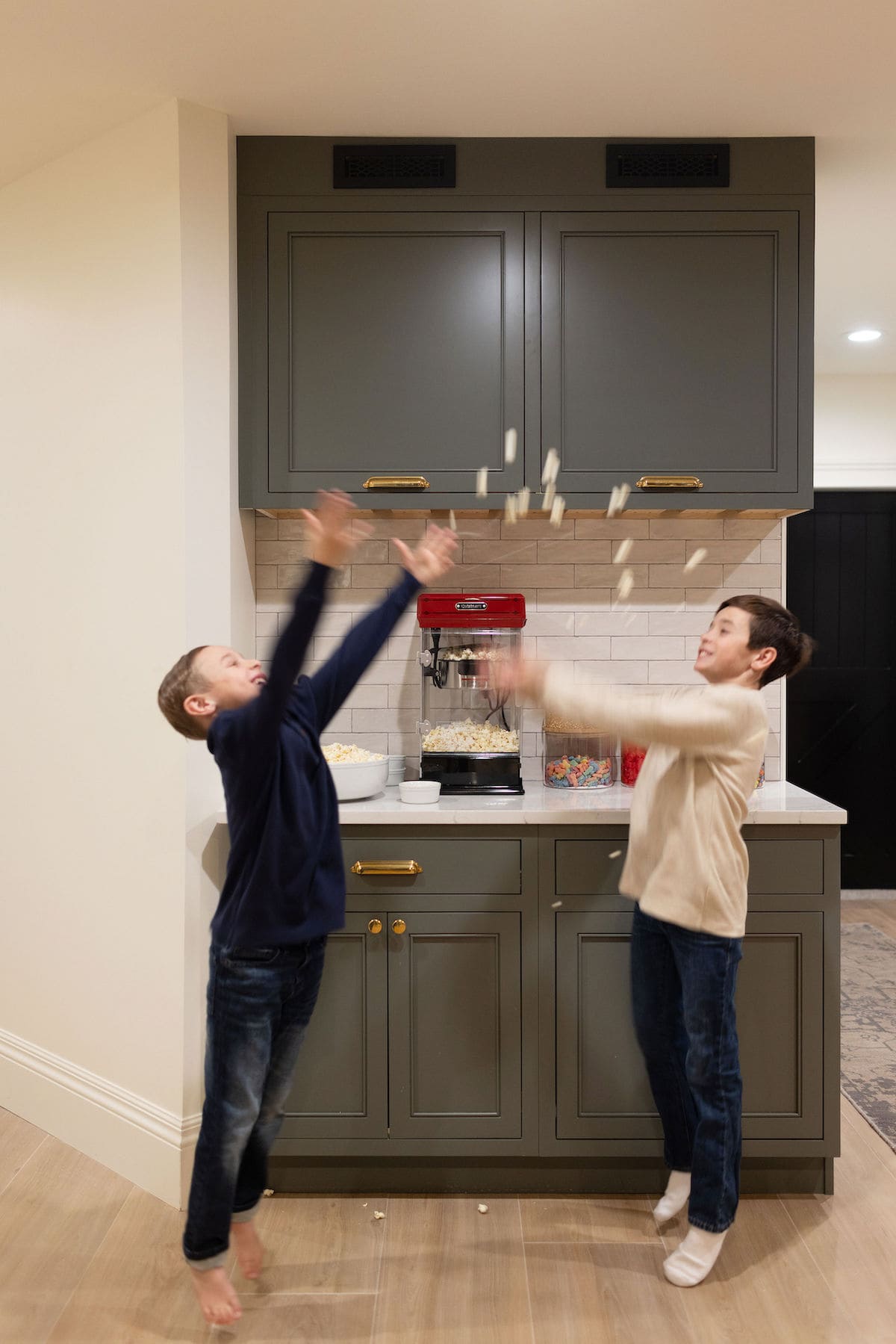 basement theatre room with popcorn maker and kids eating popcorn.