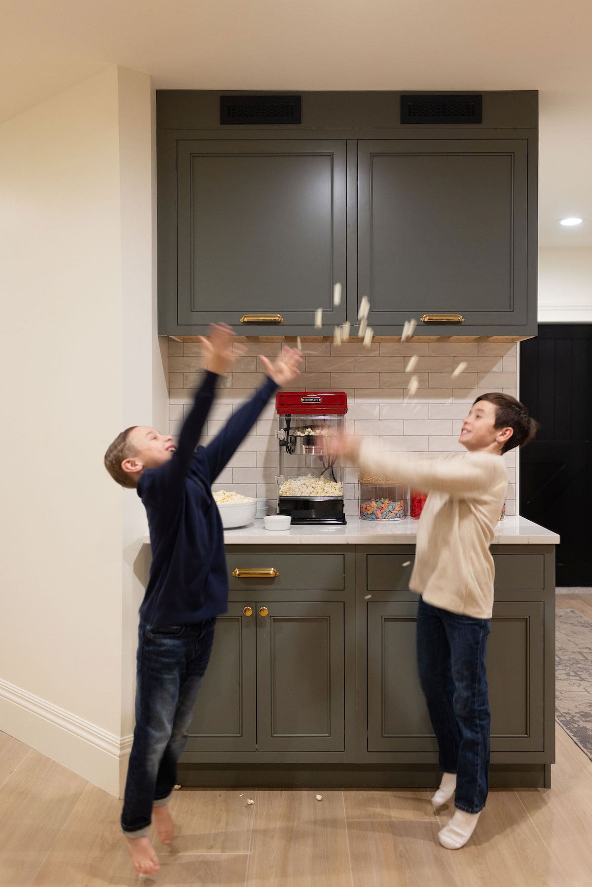 basement theatre room with popcorn maker and kids eating popcorn. 