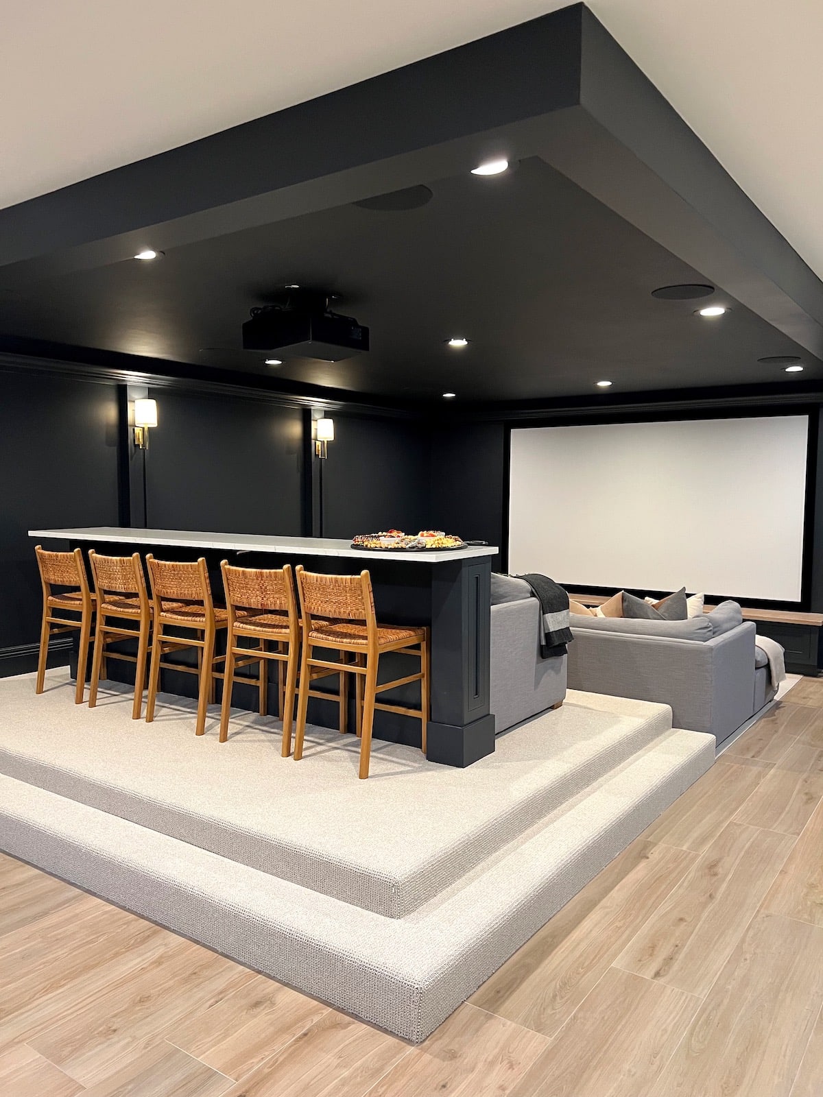 basement theatre room with bar and bar stools.