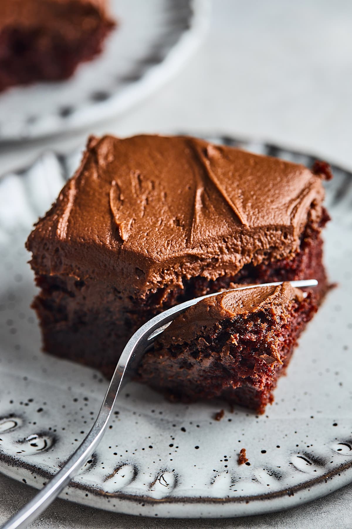 piece of chocolate cake on plate with a fork. 