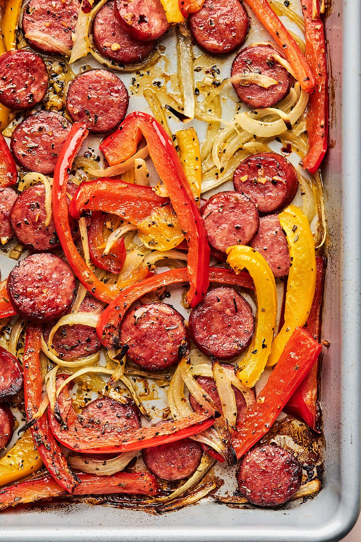 close up of cooked sausage and peppers on sheet pan. 